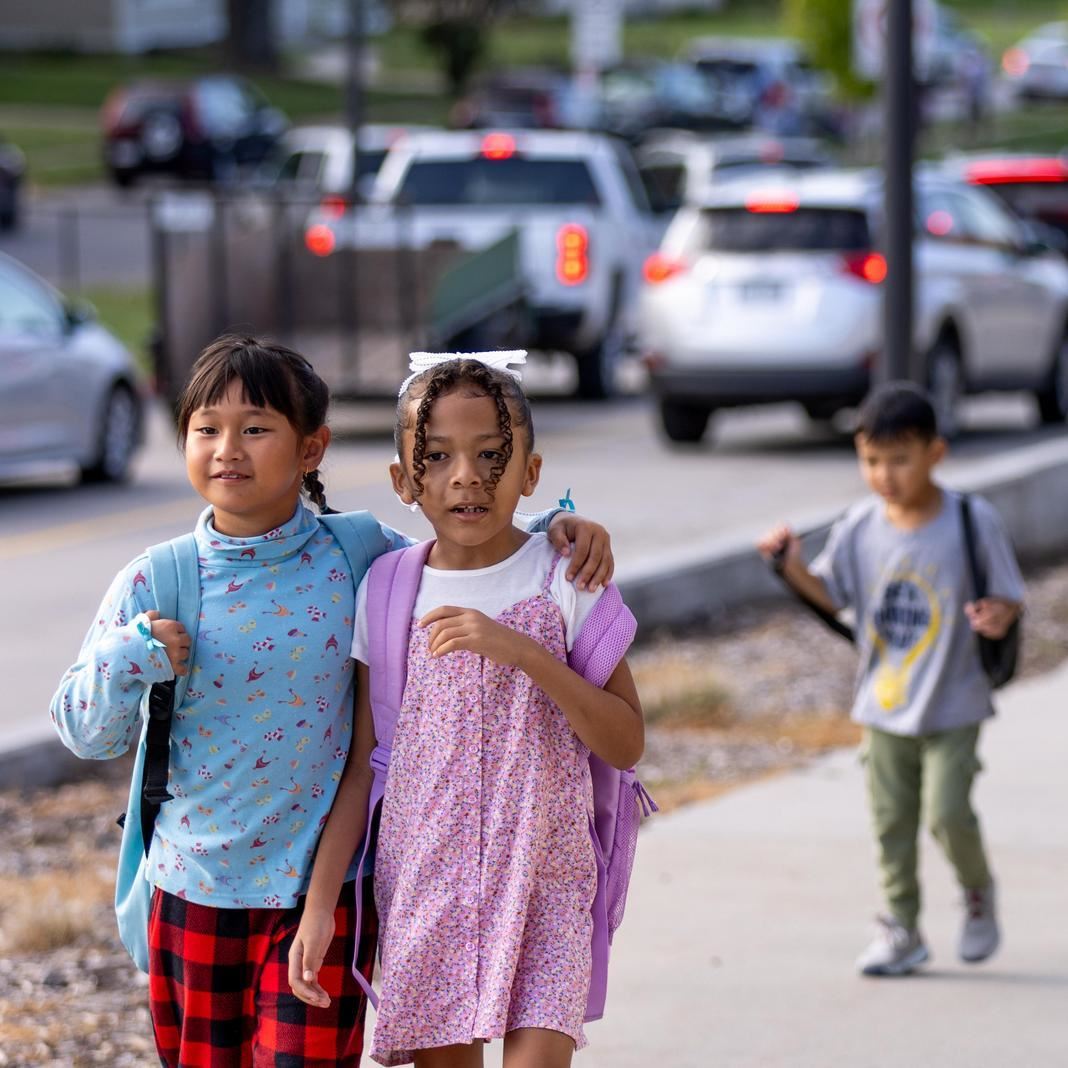  Students walk arm in arm on the way to school